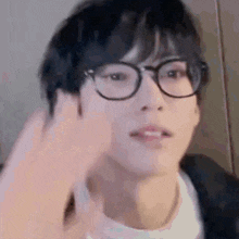 a close up of a person wearing glasses and making a funny face .