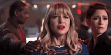 a group of people are standing next to each other and one of them is wearing a superhero costume .