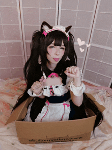 a girl in a maid costume is sitting in a cardboard box that says ob.d2qvelma.www