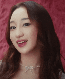 a close up of a woman wearing a necklace with a bow on it