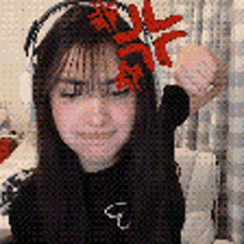 a woman wearing headphones and a flower in her hair is giving a fist bump .
