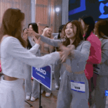 a group of women are hugging in front of a sign that says ' award '