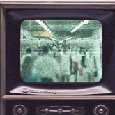 a dimly lit television screen shows a crowd of people walking