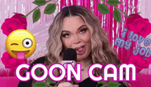 a woman is holding a microphone in front of a pink background and says " goon cam "