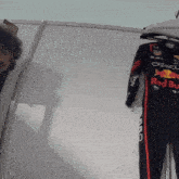 a red bull racing suit is hanging on a hanger