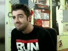 a man is wearing a black shirt that says run