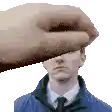 a hand is covering a man 's face in a pixelated image .