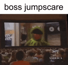 a crowd of people are watching a movie with kermit the frog on it .