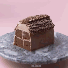 a slice of chocolate cake on a marble plate that says mr.cakes on the bottom