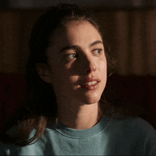 a close up of a woman 's face in a blue sweater