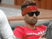 a man wearing sunglasses and a headband with the word virtual on it