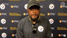 a man is standing in front of a wall with steelers logos on it