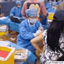 a man wearing a mickey mouse shirt is getting an injection