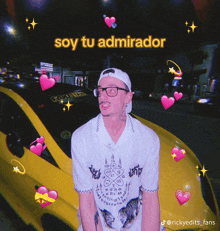 a man standing in front of a yellow car with the words soy tu admirador written above him