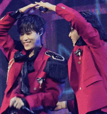 a man in a red jacket is holding a microphone in his hand