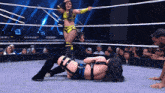 two women are wrestling in a ring and one of them is wearing a yellow top with the letter s on it