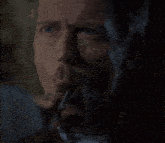 a close up of a man smoking a cigar in the dark