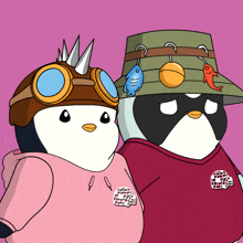 a couple of penguins standing next to each other wearing hats
