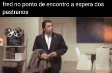 a man in a suit is standing in a room with the words fred no ponto de encontro a espera dos pastranos