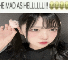 a girl with pigtails is holding a stuffed animal in her ear and the caption reads he mad as hell !!!