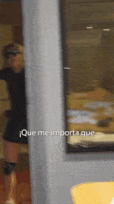 a blurred image of a woman standing in front of a window with que me importa que written on it