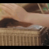 a close up of a person 's hand reaching into a basket