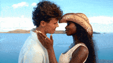 a woman wearing a cowboy hat is kissing a man