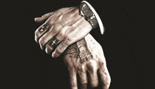 a man with a watch on his wrist has a tattoo on his hand that says ceber