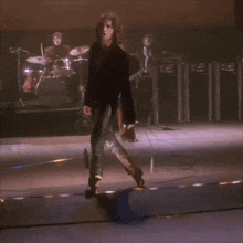 a man with curly hair is walking on a stage