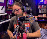 a man wearing glasses and headphones is sitting in front of a microphone ..