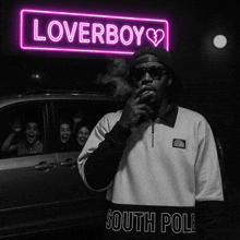 a man is smoking a cigarette in front of a neon sign that says loverboy