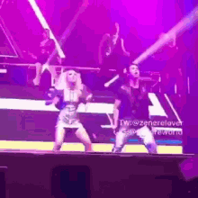 a man and a woman are dancing on a stage in front of a purple light