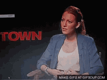 a woman sitting in front of a screen that says town