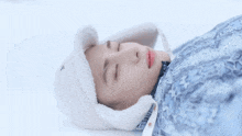 a person wearing a hat laying in the snow