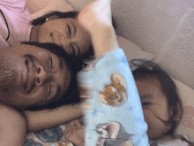 a man and a woman are laying on a bed with a tom and jerry blanket