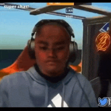a man wearing headphones and a blue hoodie is playing a video game called super chat