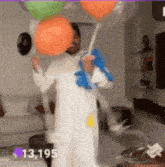 a man in a white dress is holding balloons in a living room ..
