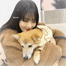 a woman is holding a dog in her arms and the dog is wearing a hoodie .
