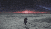a person standing in the middle of a snowy field with a red sky in the background