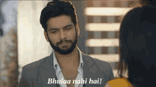 a man with a beard is looking at a woman and says bhulaa nahi hai