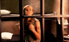 a woman in a jail cell with a tattoo on her arm that says ' i 'm sorry '