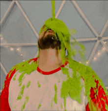 a man is covered in green slime and has a white shirt on