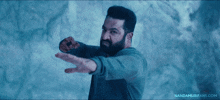 a man with a beard is pointing his finger at the camera with nandamurifans.com written below him