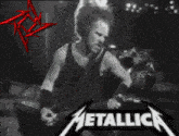 a black and white photo of a man playing a guitar with the metallica logo in the corner