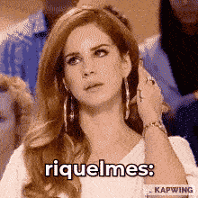 a woman in a white shirt says " riquelmes " in a pixelated image