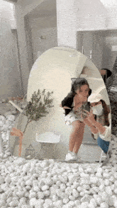 two girls are taking a picture of themselves in a mirror surrounded by white rocks .