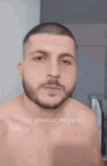 a shirtless man with a beard is looking at himself in a mirror with a caption in a foreign language