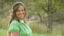 a woman in a green shirt is smiling with the words " thank you michelle " behind her