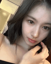 a close up of a woman taking a selfie with her hand on her hair