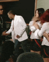 a group of people are standing in a room and talking